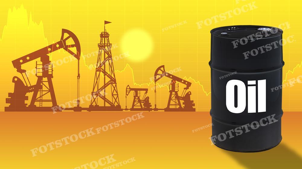 На изображении представлена черная нефтяная бочка с надписью "Oil" на переднем плане. На заднем плане силуэты нефтедобывающих установок, включая вышки и насосы-качалки, на фоне яркого, оранжево-желтого закатного неба с графиками колебания цен на нефть. Это фото может использоваться в публикациях, посвященных нефтяной промышленности, энергетическом секторе, изменениях в ценообразовании на энергоносители и рыночной экономике.